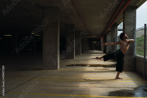 Chico bailando en parking y frente pared roja © MiguelAngelJunquera