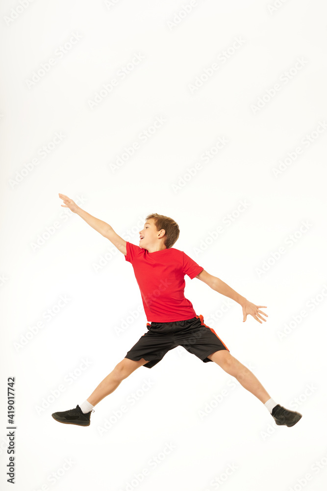 Adorable boy jumping and reaching out hand to something
