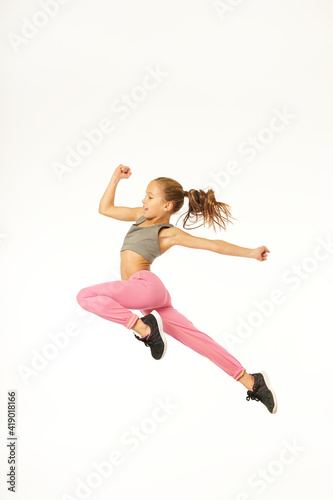 Cute sporty girl jumping against white background
