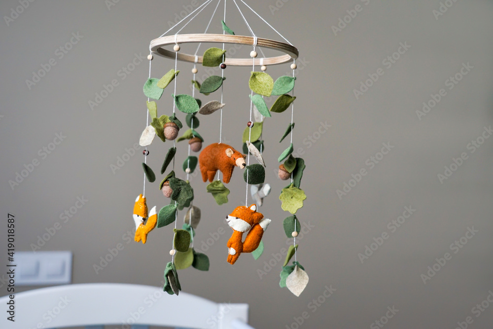 Diy craft baby crib mobile. Toys hang over the crib