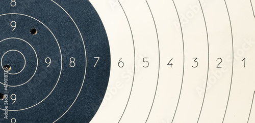 Target with numbers for shooting at a shooting range. A round target with a marked bull's-eye for shooting practice on the shooting range. Target with bullet holes photo