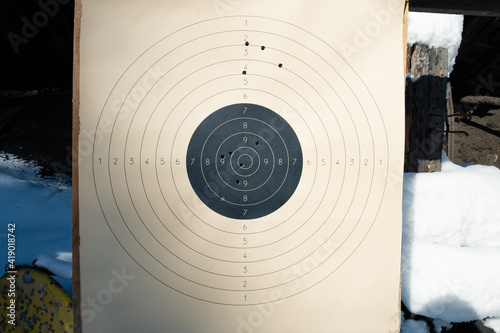 Target with numbers for shooting at a shooting range. A round target with a marked bull's-eye for shooting practice on the shooting range. Target with bullet holes