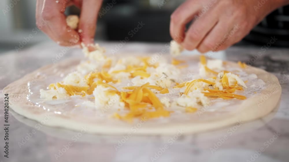 Chef spreading sour cream and cheese over pizza dough, cooking italian pizza. Tasty traditional street fast food, high kitchen restaurant