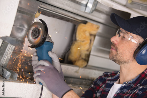 builder using angle grinder and making sparks