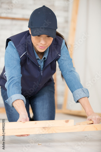 woman kneeling on the floor assembling wood