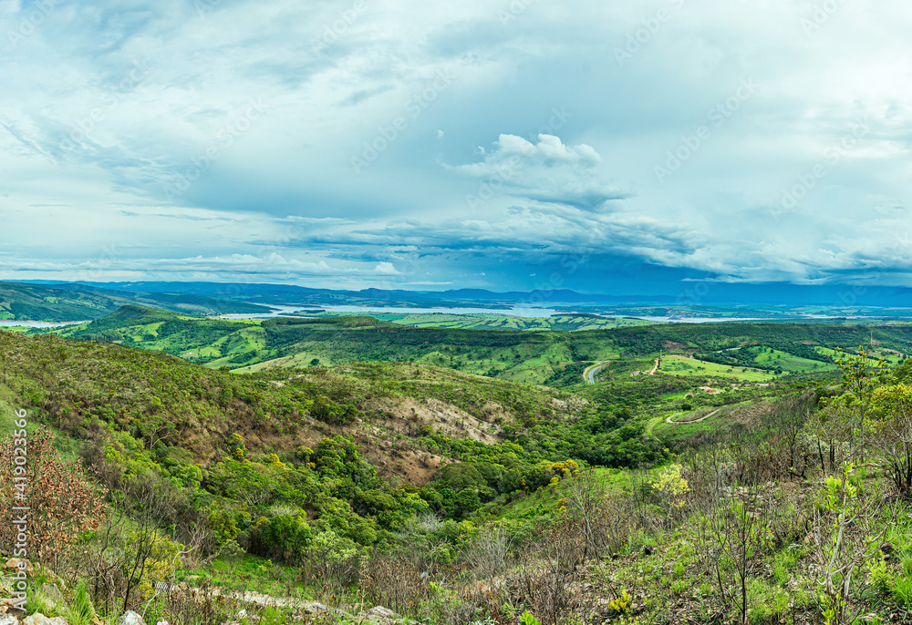 Wide panoramic view of nature beauties of Minas Gerais state. Vast green area with 
a mountainous terrain and the Lake of Furnas on background. Capitólio MG, Brazil.