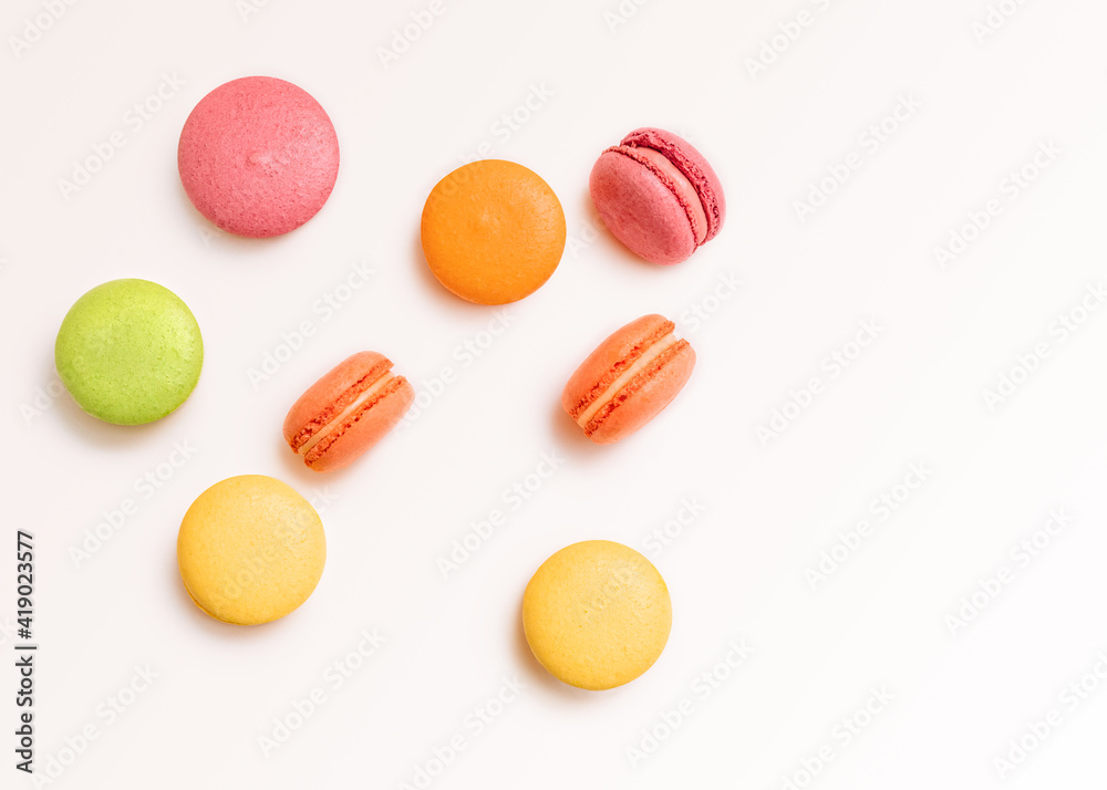 French biscuits Top view photo in minimal style Pink, orange, yellow, and green almond cookies on white background French biscuits Top view photo in minimal style Pink, orange, yellow, and green almond cookies on white background