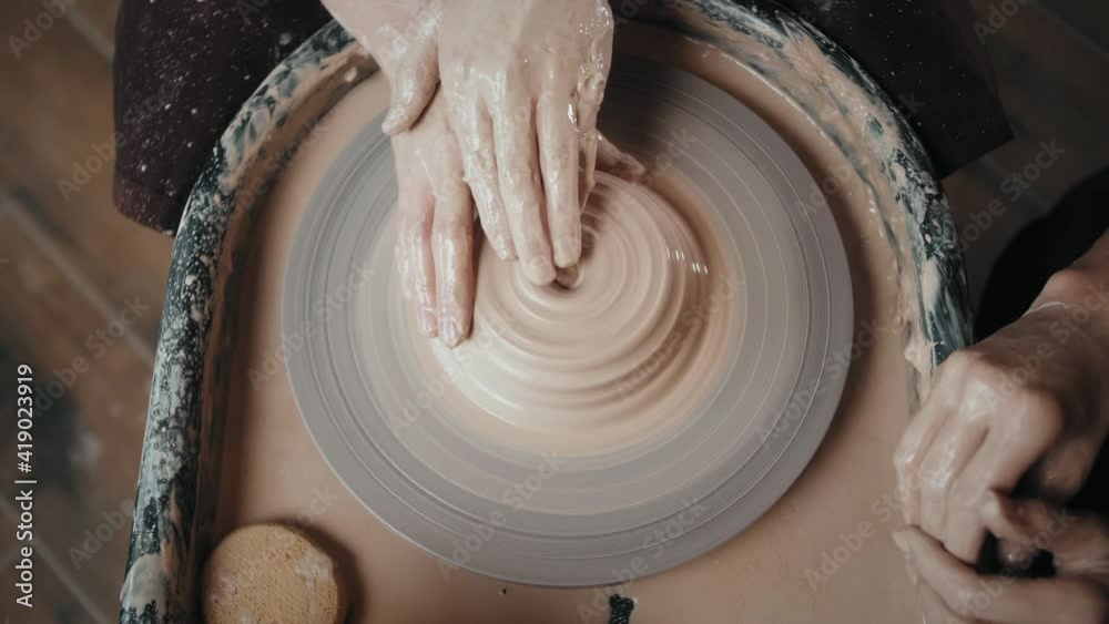 Man potter working on potters wheel making ceramic pot from clay in pottery workshop. Traditional arabian art concept, creative workshop and masterclass. Man potter working on potters wheel making ceramic pot from clay in pottery workshop. Traditional arabian art concept, creative workshop and masterclass.