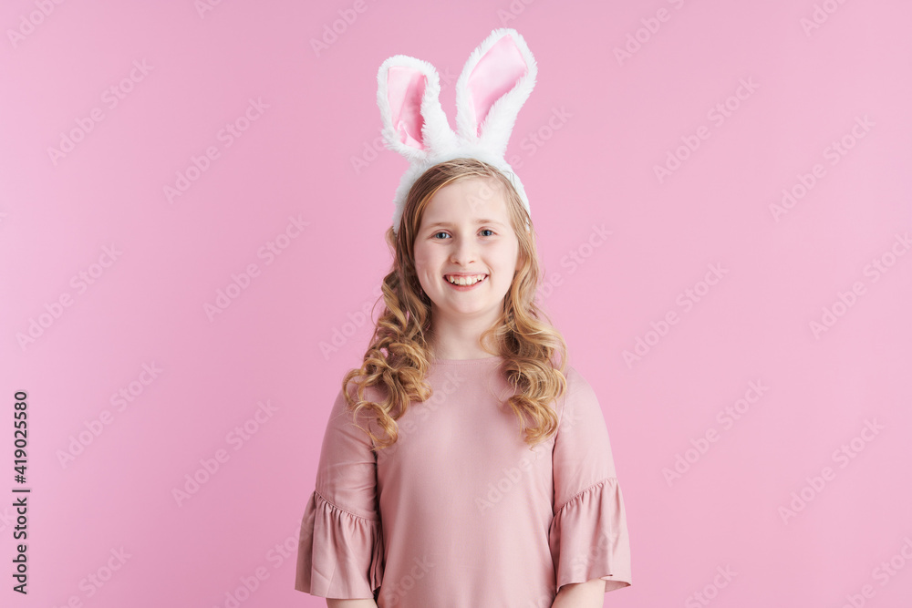 Portrait of happy stylish child in pink dress on pink