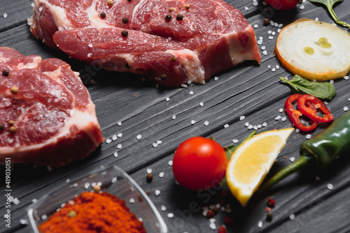 raw meat with fresh vegetables and spices on wooden background. Top view. Free space for text. prepare yourself concept