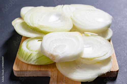 Sliced onion placed on a wooden board. Vegetables in the kitchen prepared to serve.