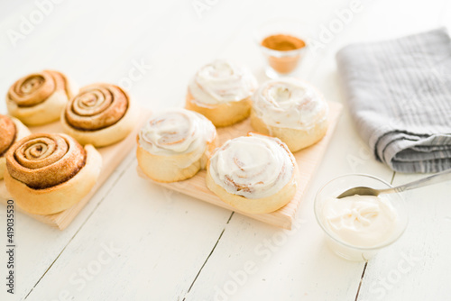 Cinnamon rolls with white icing on a wooden table