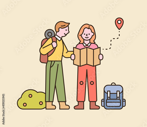 A couple is backpacking. They are standing on the road and looking at the map. flat design style minimal vector illustration.