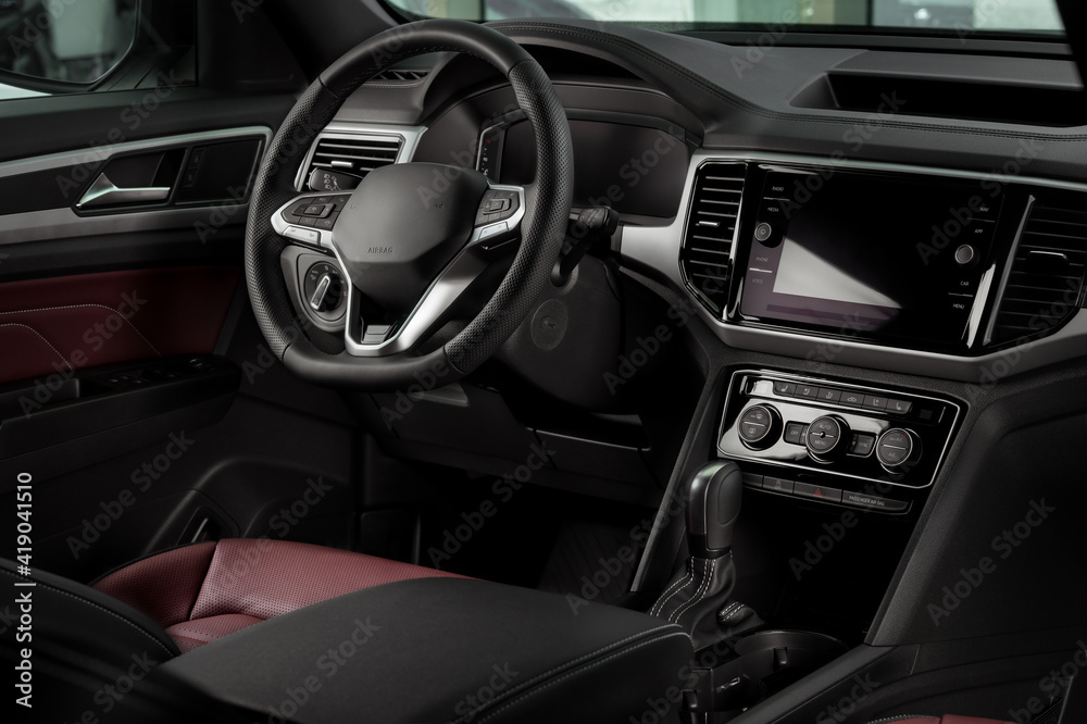 New automobile interior details with leather steering wheel, automatic transmission and touchscreen center console New automobile interior details with leather steering wheel, automatic transmission and touchscreen center console
