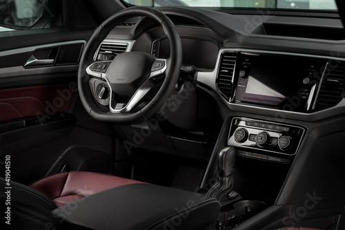New automobile interior details with leather steering wheel, automatic transmission and touchscreen center console