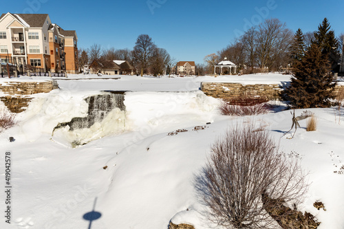 Ice-cold water falls from the mill pond falls into snow in Menomonee Falls, Wisconsin
 photo