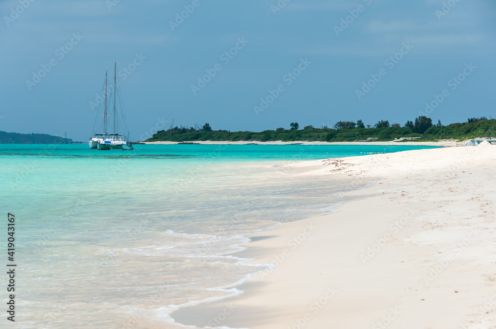 White sand beach, emerald green sea and a catamaran docked in its beautiful transparent waters. Miyako Island. White sand beach, emerald green sea and a catamaran docked in its beautiful transparent waters. Miyako Island.