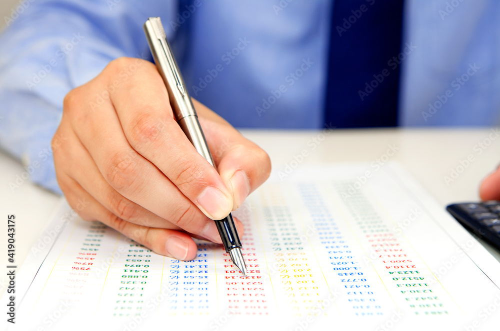 Male hand with pen checking bill Male hand with pen checking bill