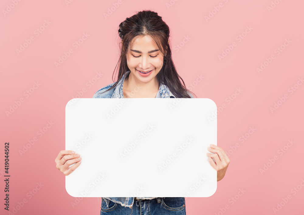 Happy Asian beautiful young woman smiling excited wear denims holding empty speech bubble sign, Portrait female posing show up for your idea looking at bubble, studio shot isolated on pink background Happy Asian beautiful young woman smiling excited wear denims holding empty speech bubble sign, Portrait female posing show up for your idea looking at bubble, studio shot isolated on pink background