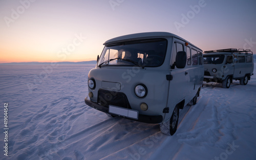 Russian Off-road vans parking on frozen lake Baikal after sunset. The UAZ van is popular off-road van for travelling lake Baikal.