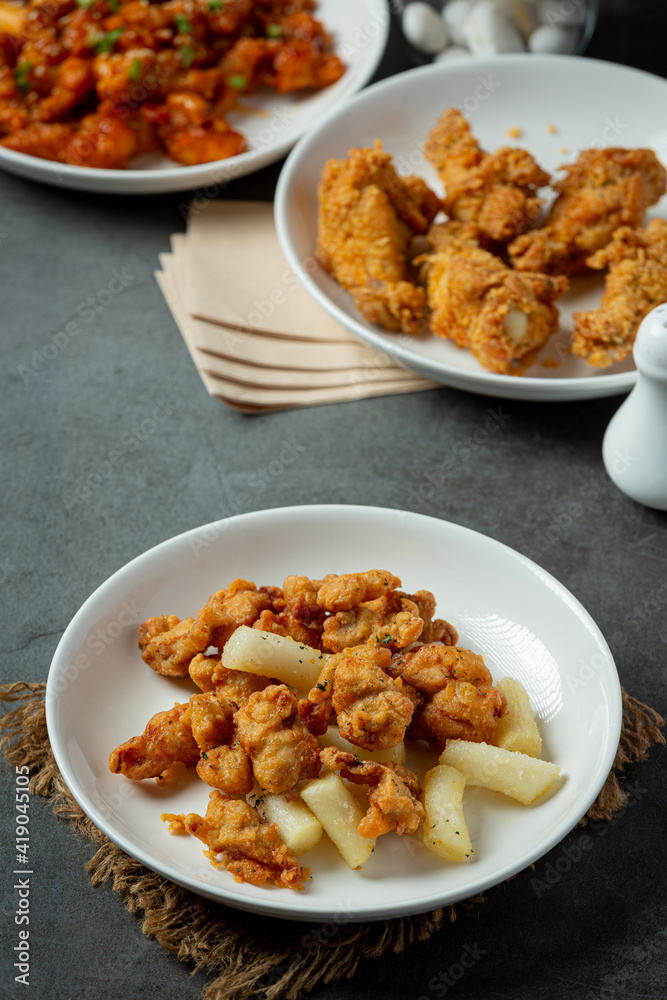 Fried tteokbokki and chicken on dark background Fried tteokbokki and chicken on dark background