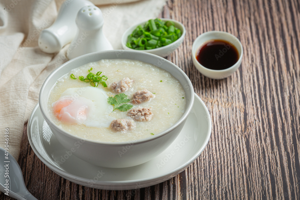 congee with minced pork in bowl on wooden background congee with minced pork in bowl on wooden background