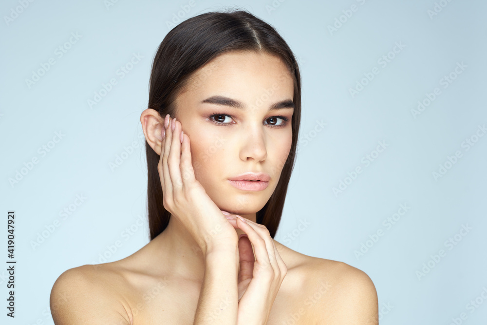 Woman with naked shoulders long hair clean skin cropped view blue background Woman with naked shoulders long hair clean skin cropped view blue background
