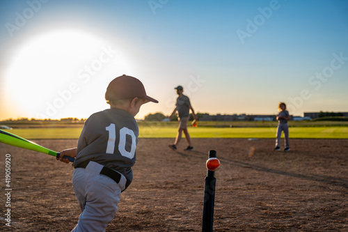 Canvastavla Caucasian boy with baseball bat at home plate swinging at ball on tee