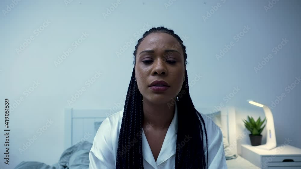 Pretty African American woman talks to someone on a video call, yawns ...