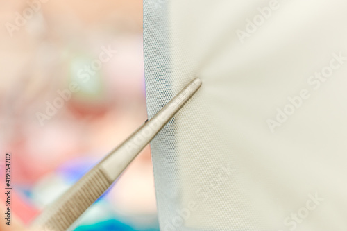 Close-up of a compress holding with forceps. Action step of nurse occupation: doing a sterile dressing , wound care concept