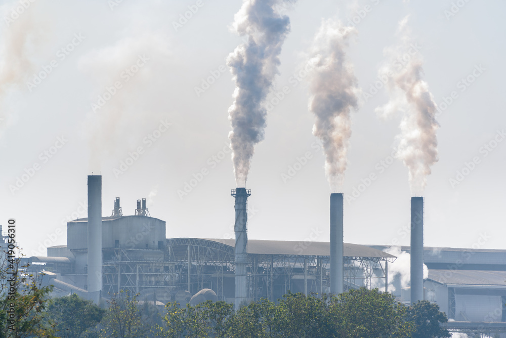 White smoke comes out from smokestacks or exhaust pipes. Factory