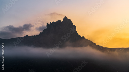 Mountain peak in the fog at sunset