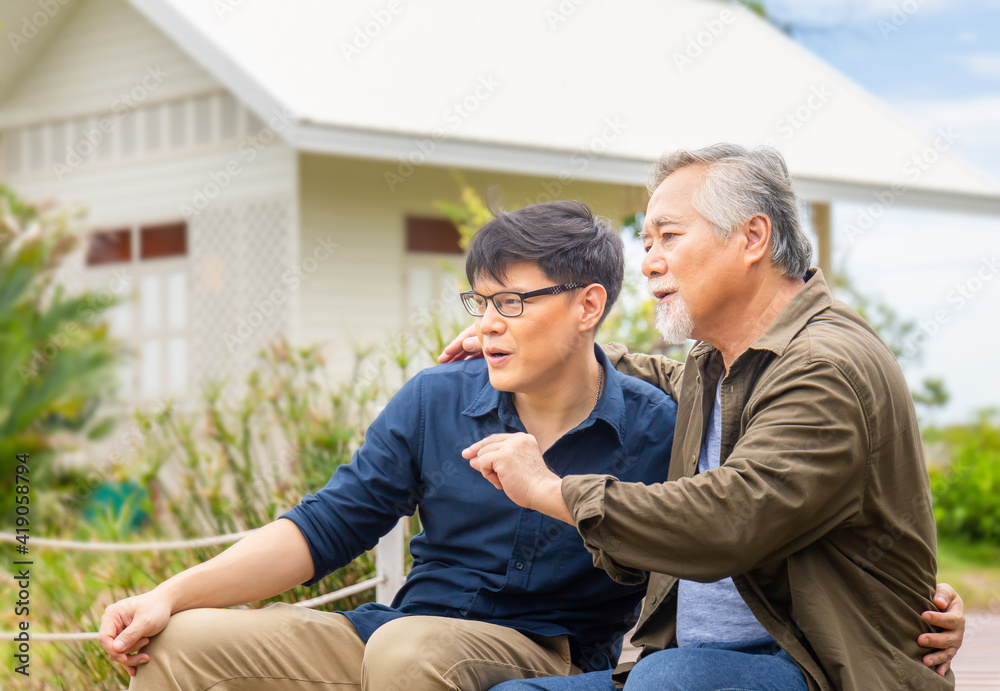 Senior asian father and middle aged son sitting relax together outdoors, Senior father give advice adult son, Happiness asian family concepts Senior asian father and middle aged son sitting relax together outdoors, Senior father give advice adult son, Happiness asian family concepts