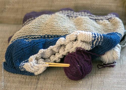 Fototapeta Naklejka Na Ścianę i Meble -  knitted colorful sweater with knitting needles and a ball of yarn