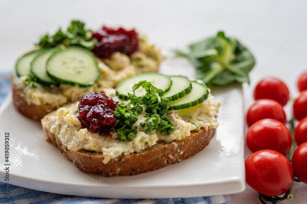 sandwich dip bread spread with salad vegetables on white porcelain plate 