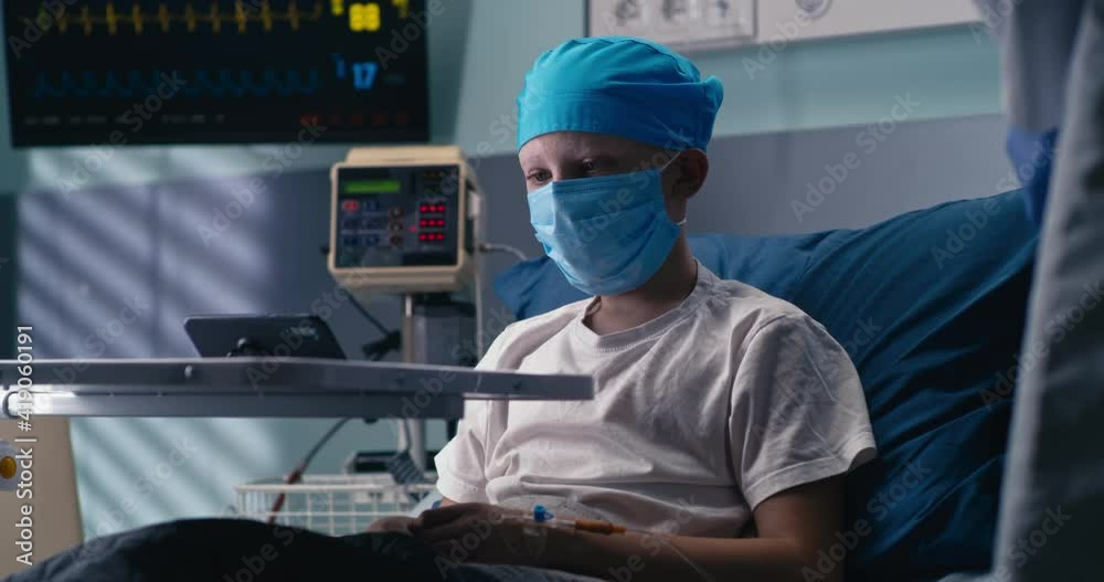 Boy in mask making video call from oncology hospital