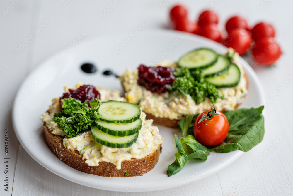 sandwich dip bread spread with salad vegetables on white porcelain plate sandwich dip bread spread with salad vegetables on white porcelain plate
