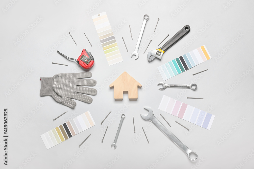 Frame made of house figure and construction tools on light background Frame made of house figure and construction tools on light background