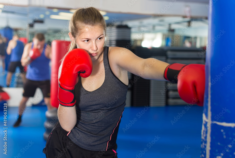 Portrait of young belorussian woman who is training in box gym.