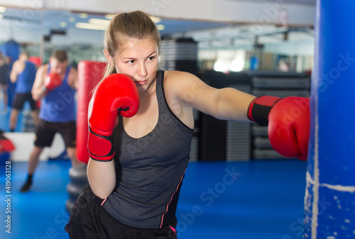 Portrait of young belorussian woman who is training in box gym. © JackF
