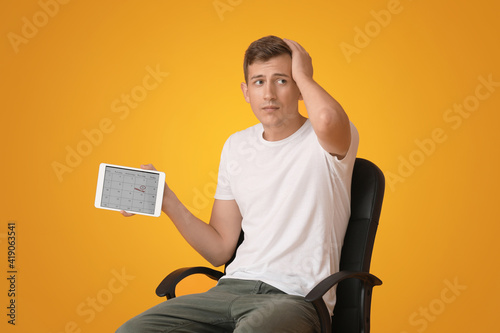 Stressed young man with tab...