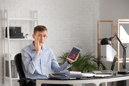 Stressed young man with tab...