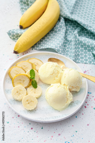 Plate with tasty banana ice-cream on light background