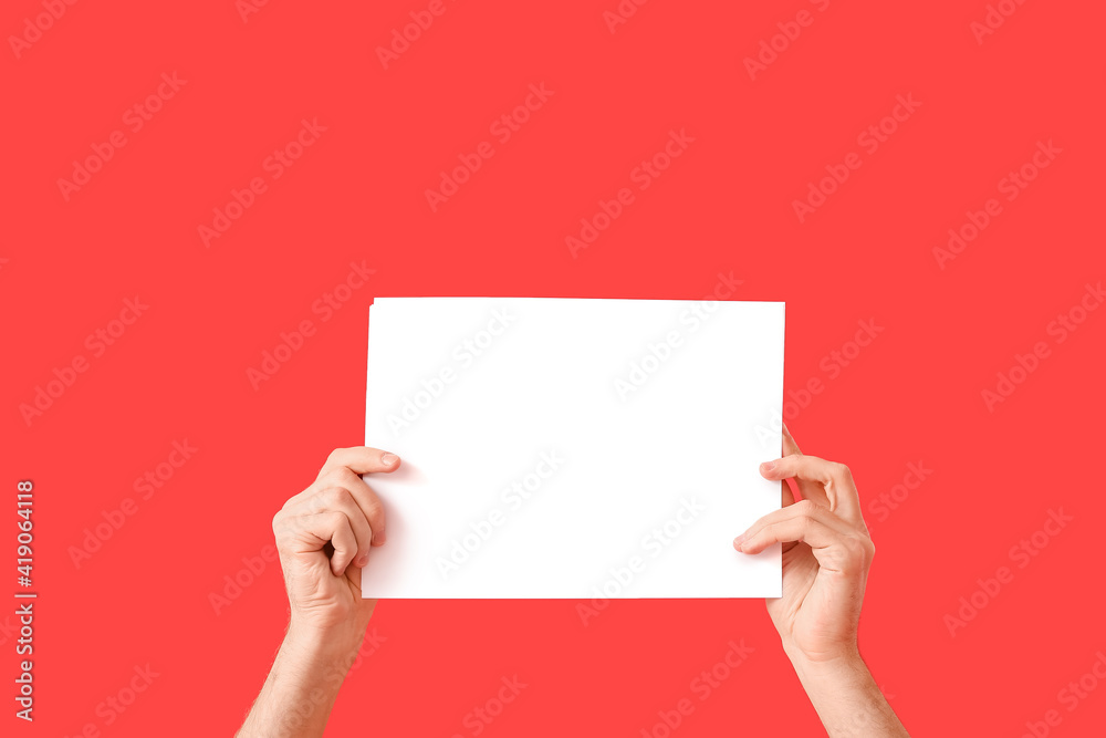 Male hands with empty paper sheet on color background Male hands with empty paper sheet on color background