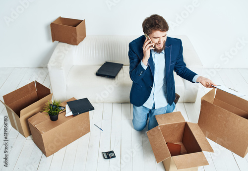 man talking on the phone unpacking boxes office work new place businessman photo