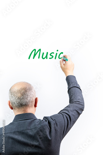 Man writing the word Music on a white background with green marker pen