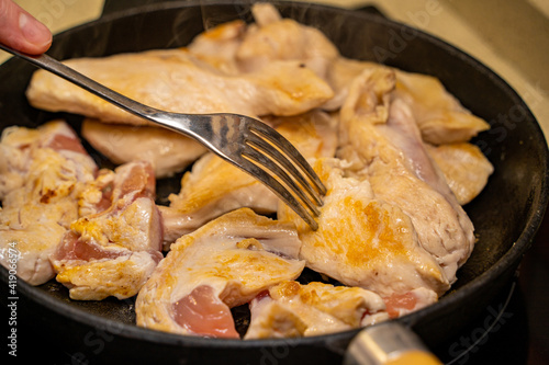 Pieces of chicken breast with a golden crust are fried in a pan. Protein-rich healthy food. Diet food at home.