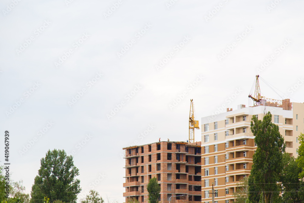 Construction workplace in the summer. Details of unfinished building on the construction site: Floors, windows and balconies. The erection of a new residential multi-storey house Construction workplace in the summer. Details of unfinished building on the construction site: Floors, windows and balconies. The erection of a new residential multi-storey house