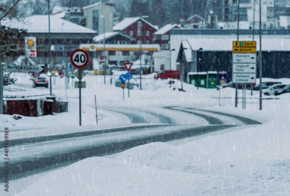 Naklejka premium Road covered in snow and ice leading out of a small city center in Norway.