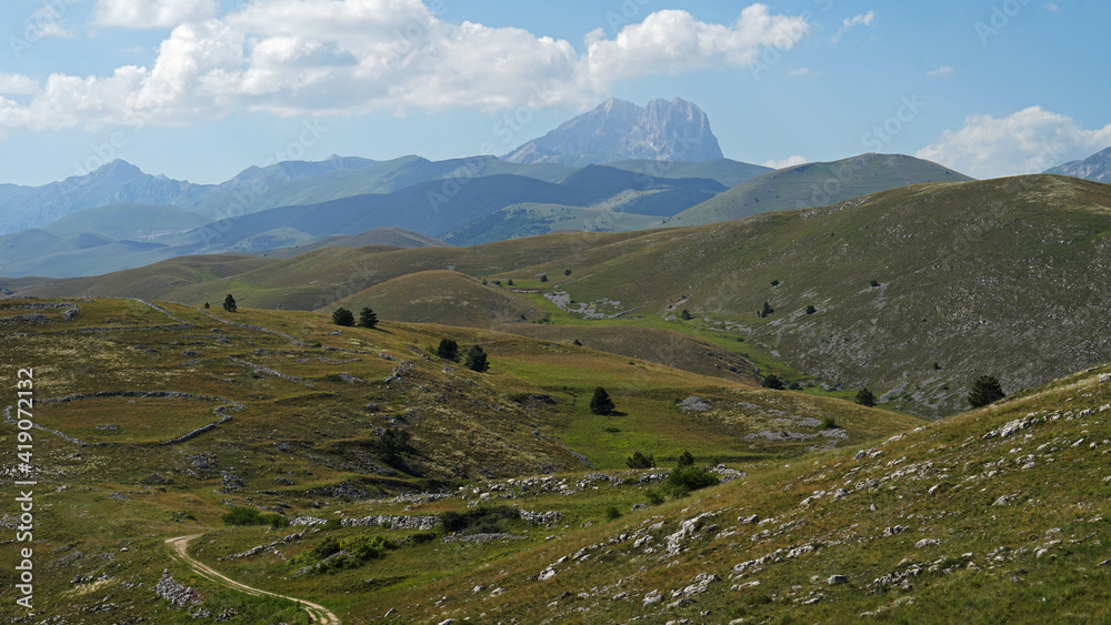 Apennine Mountains grassy landscape with highest Corno Grande Mountain, Gran Sasso and Monti della Laga National Park, Abruzzo, Italy